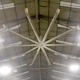 Large fan installed on ceiling of a warehouse.