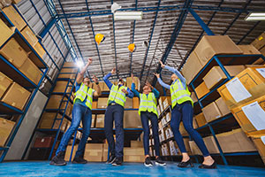 Happy warehouse employees celebrating an achievement. 